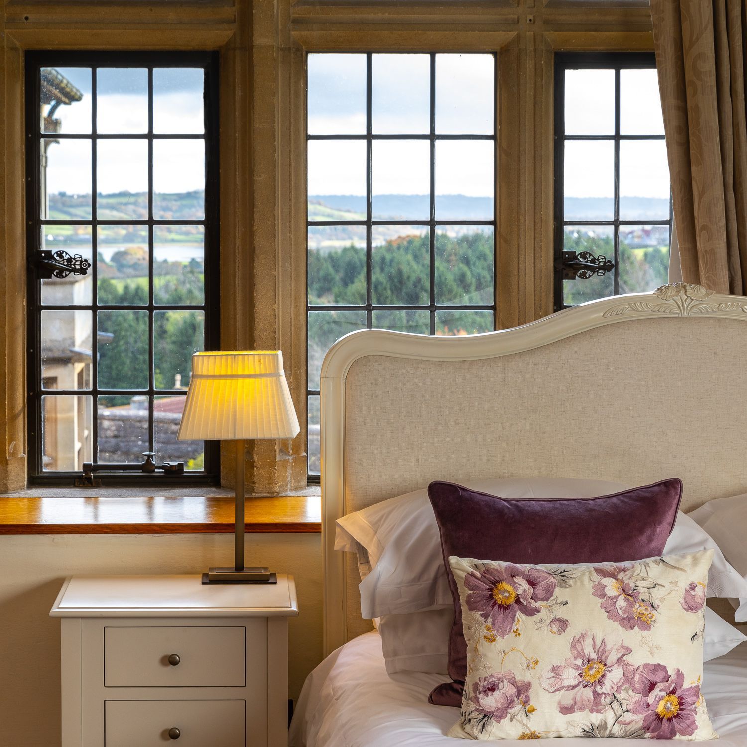 A bedroom with a bed a nightstand and a lamp