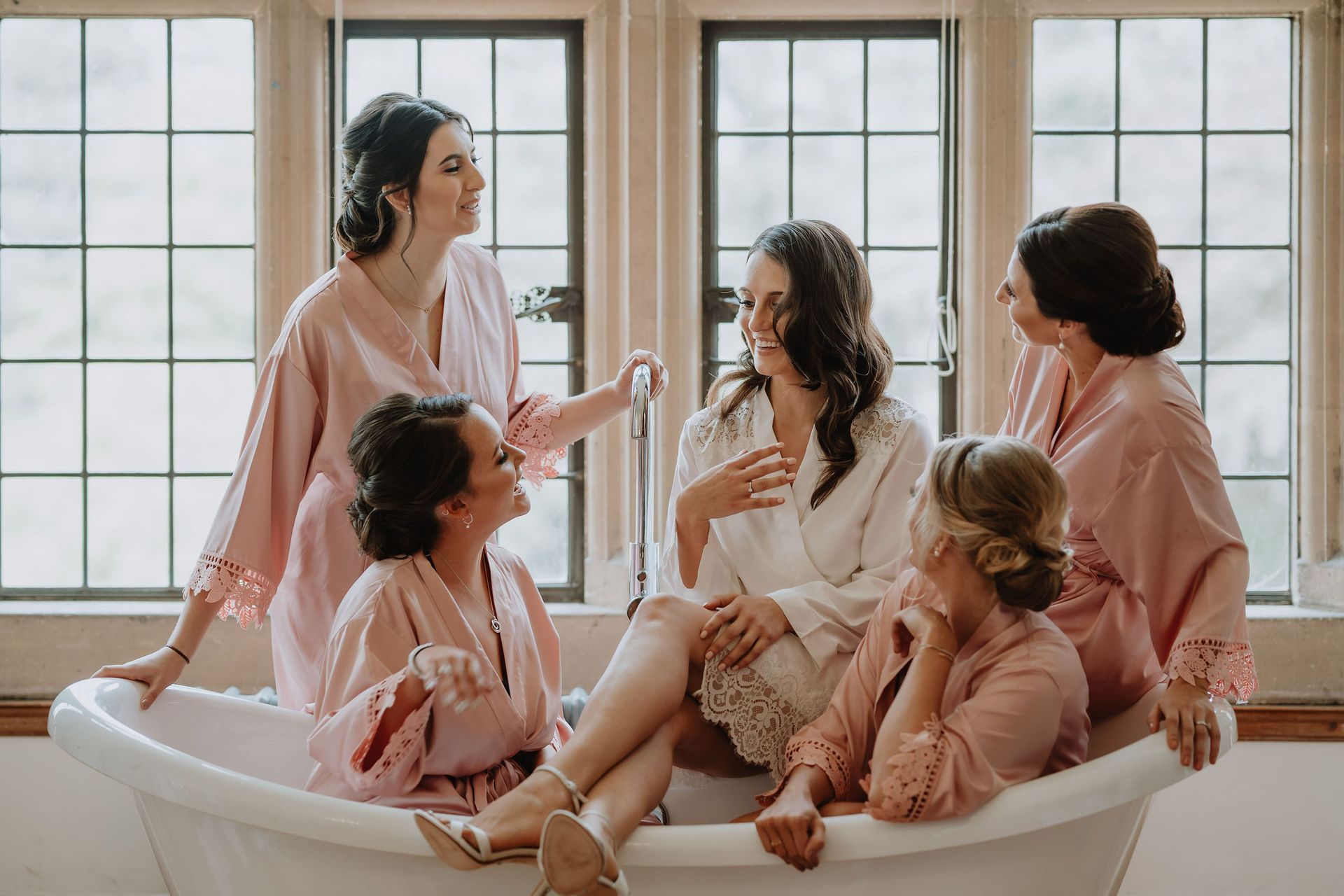 A group of women are sitting in a bathtub.