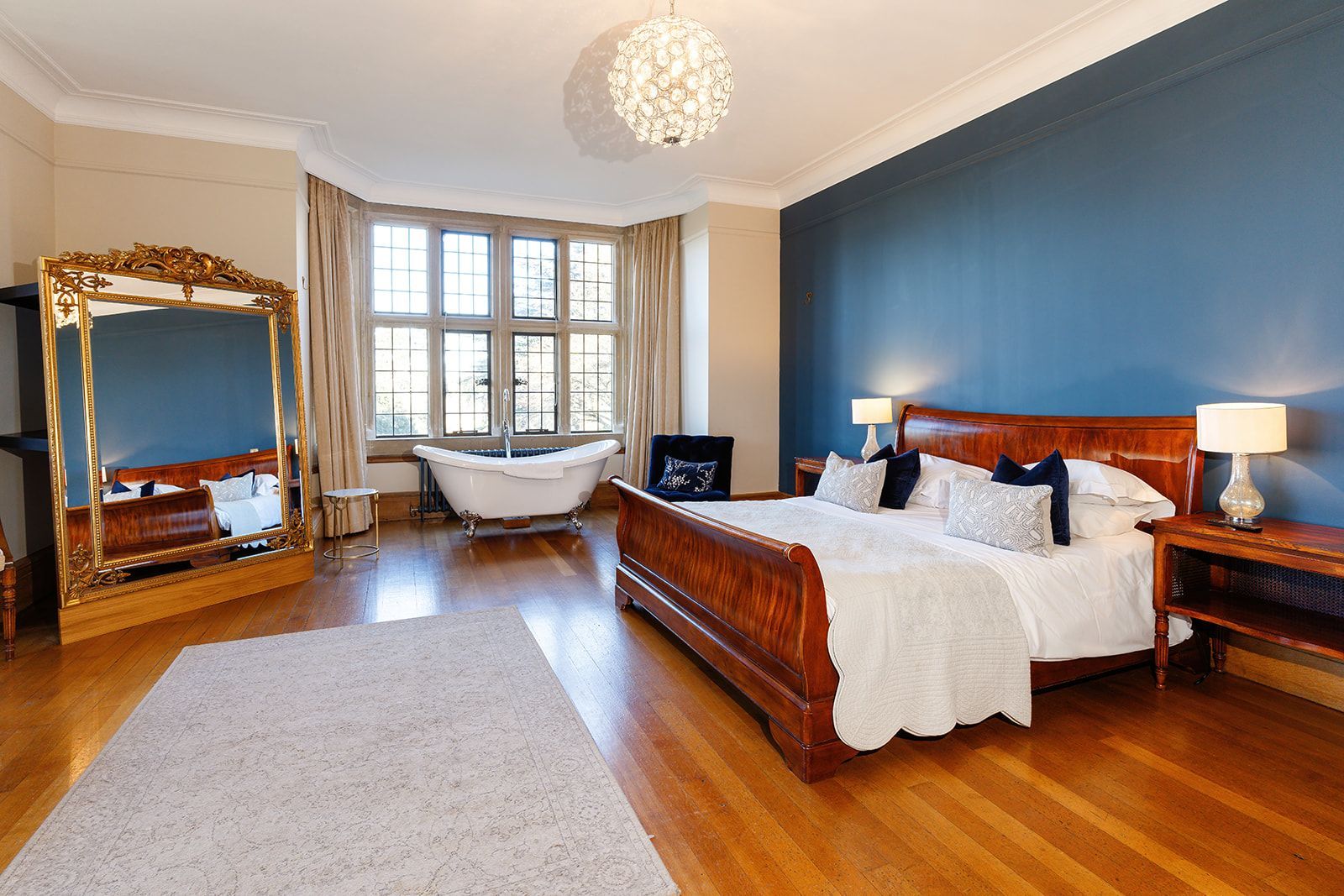 A bedroom with a large bed and a bathtub