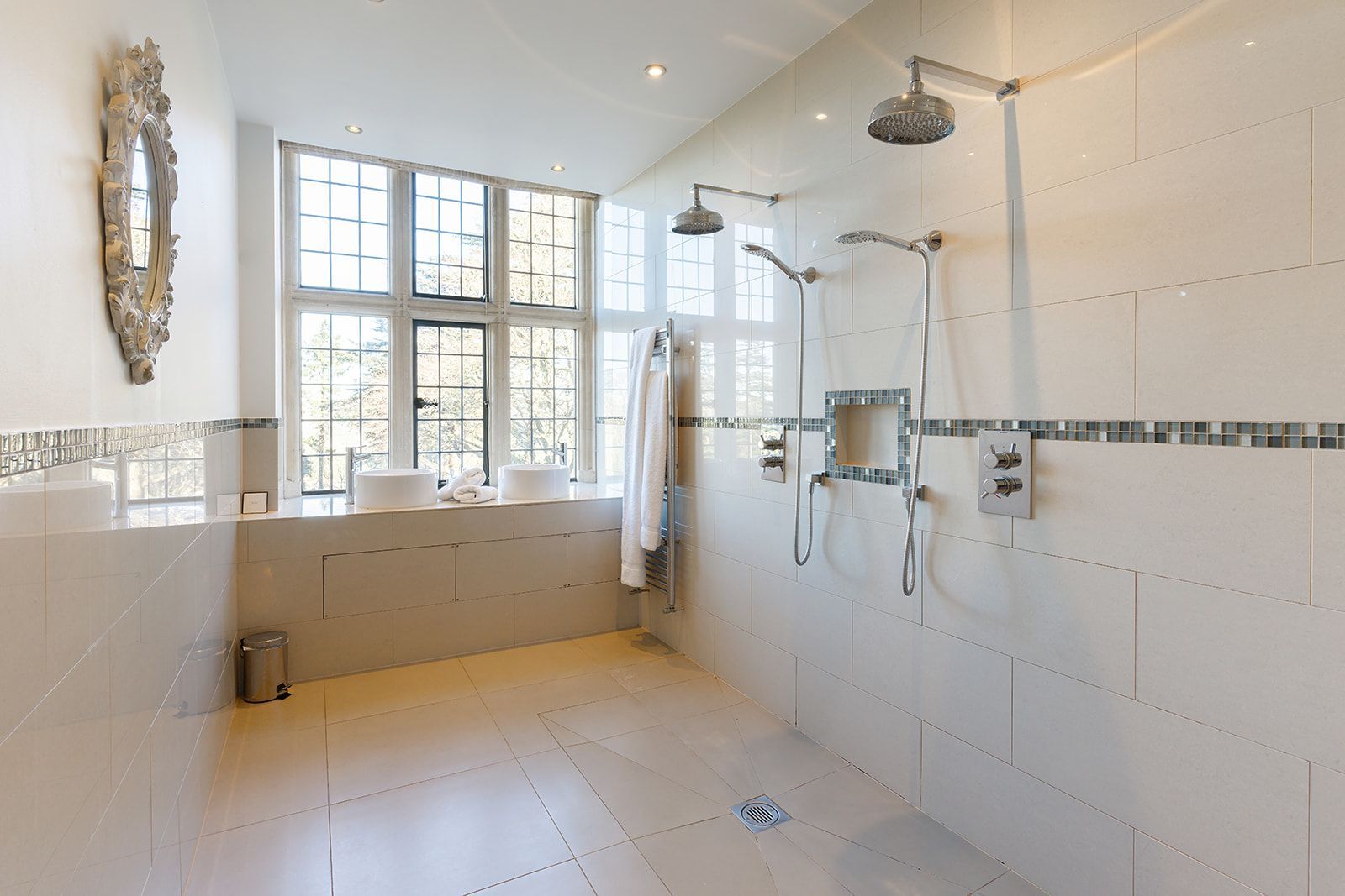 A bathroom with two sinks and a walk in shower.