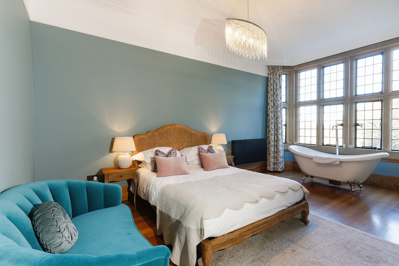 A bedroom with a large bed and a bathtub.