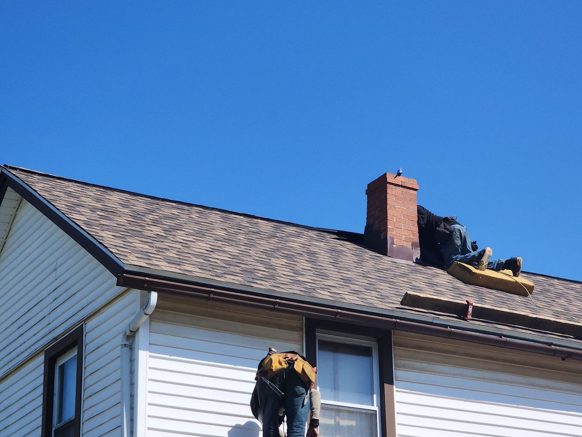 A man is working on the roof of a house