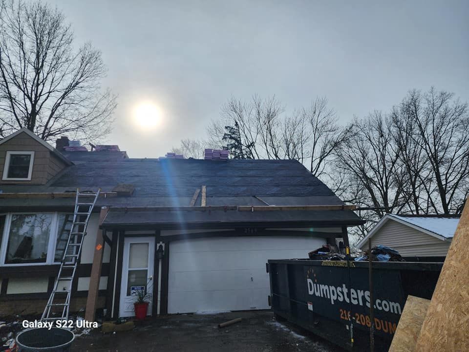 A house is being remodeled with a dumpster in front of it.