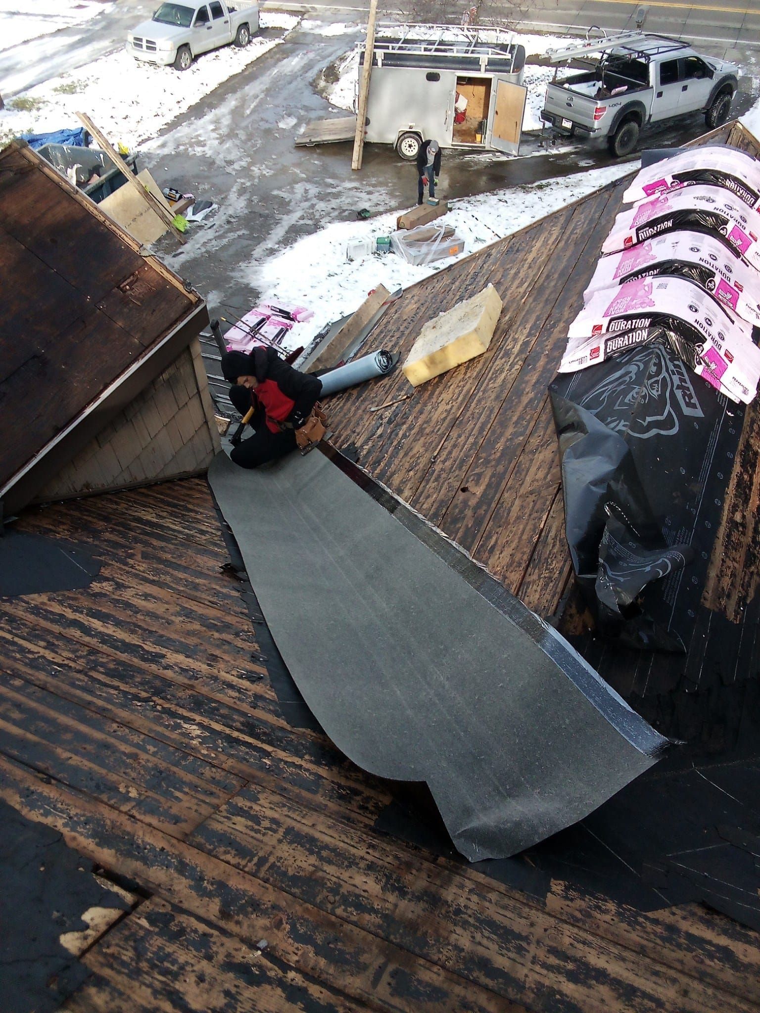 A person is working on a roof with a pair of pliers.