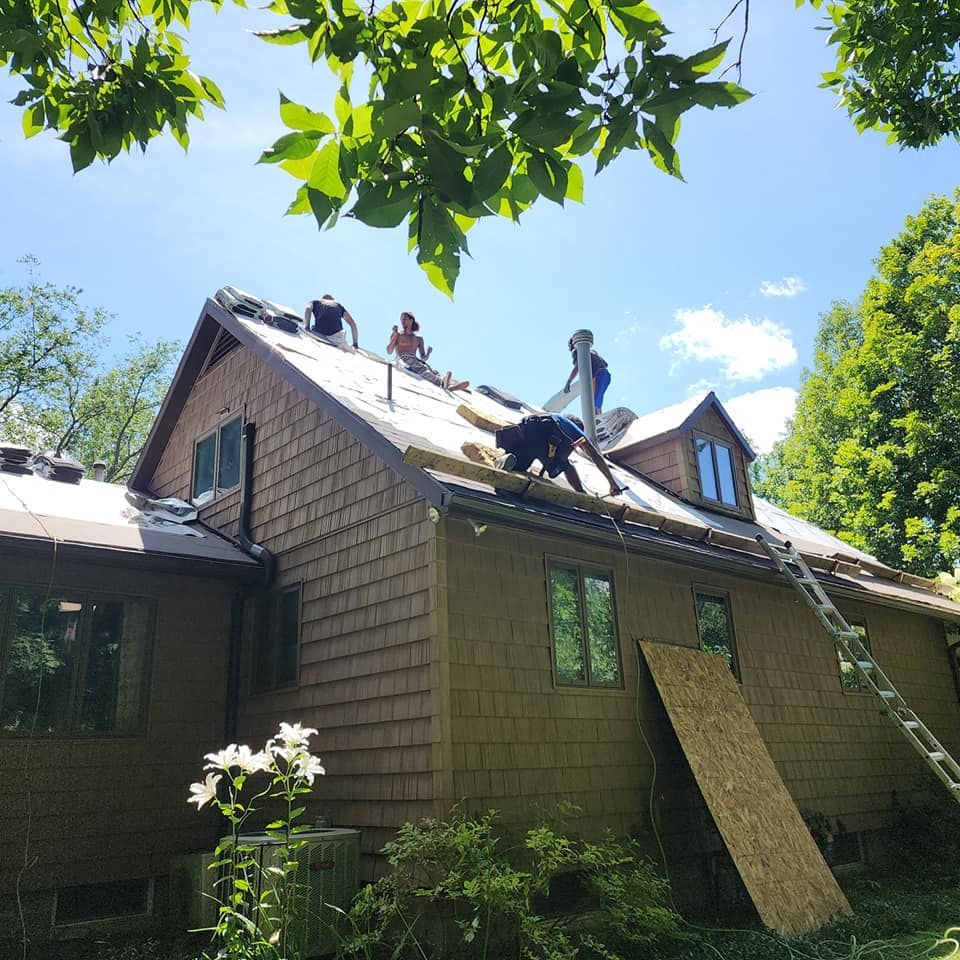 A group of people are working on the roof of a house