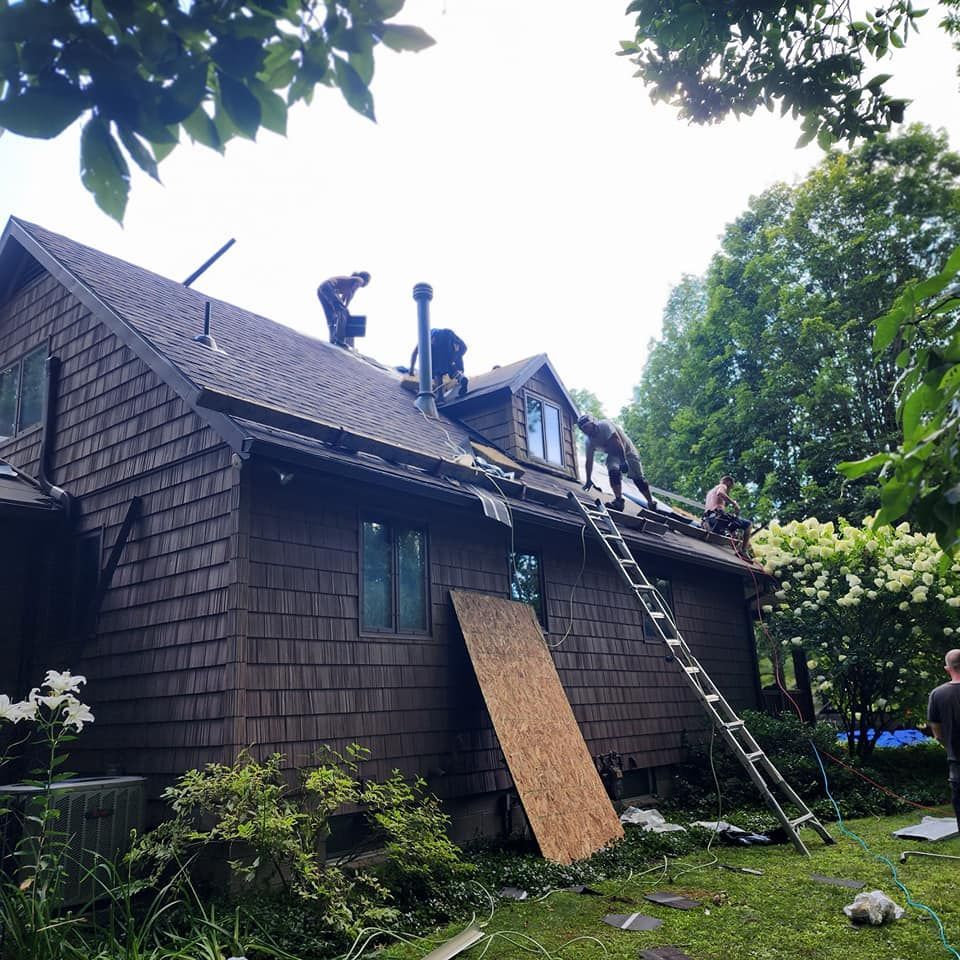 A group of people are working on the roof of a house