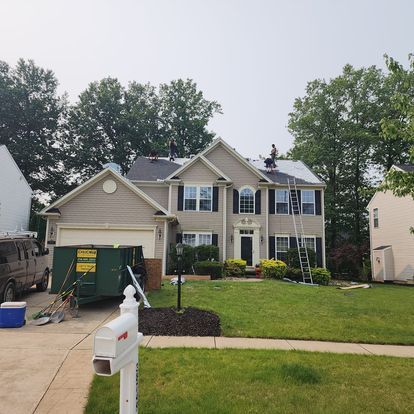 A large house with a green dumpster in front of it