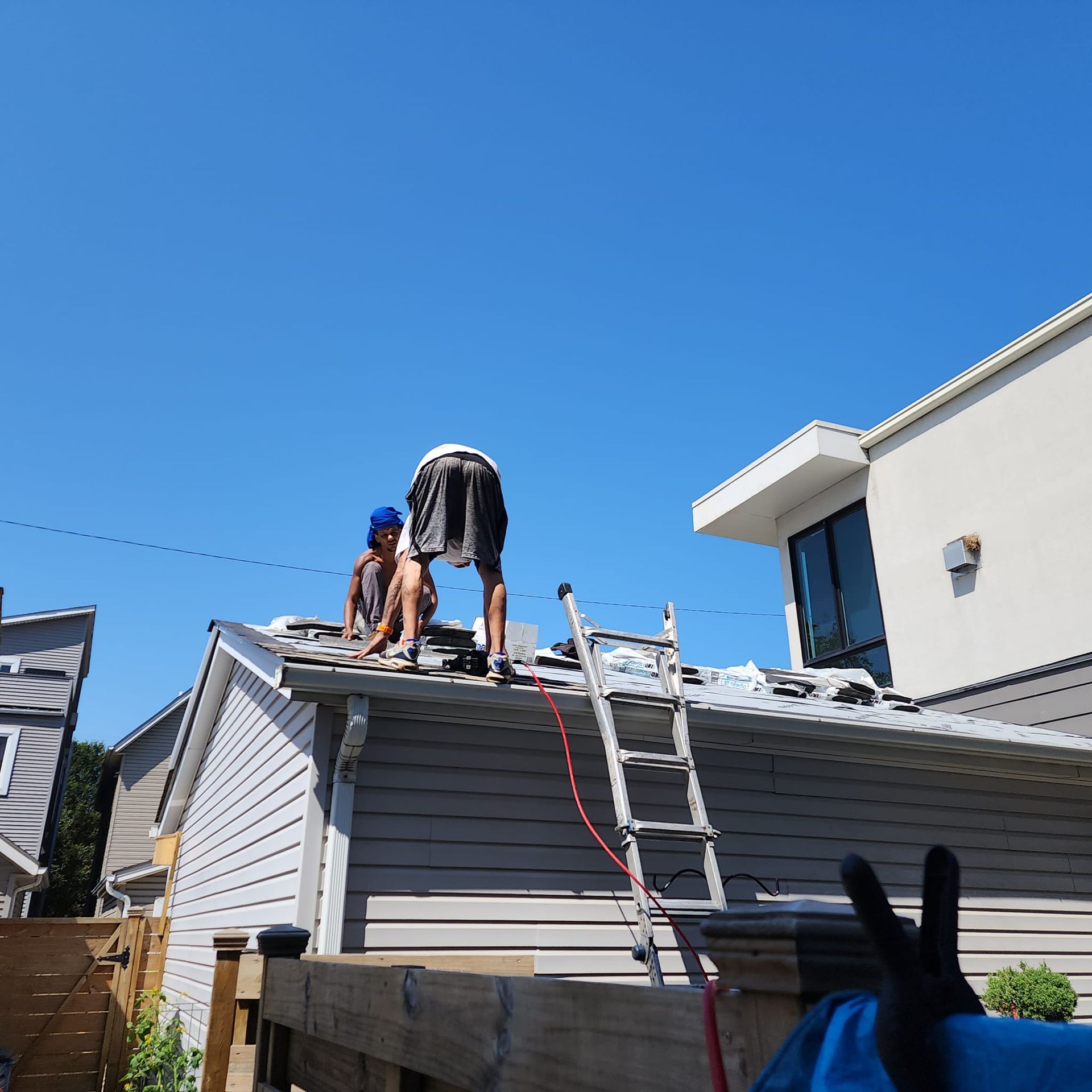 Two men are working on the roof of a house