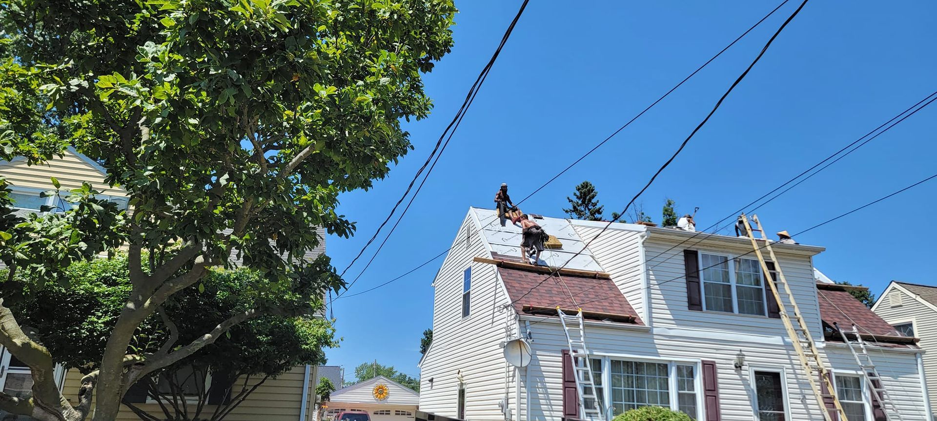 A group of people are working on the roof of a house.