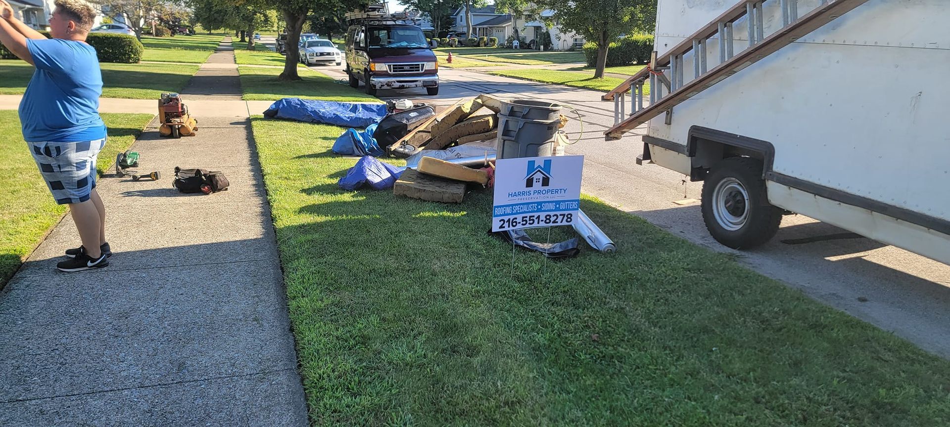 A man is standing on a sidewalk next to a trailer.