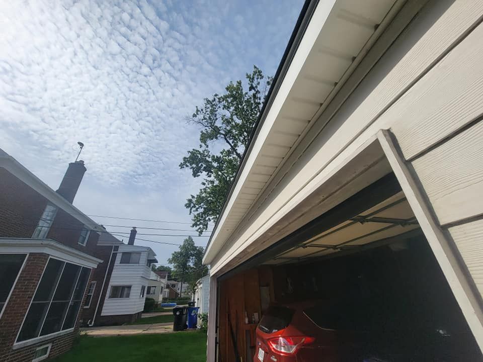 A red car is parked in a garage next to a house.