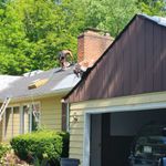 A man is working on the roof of a house