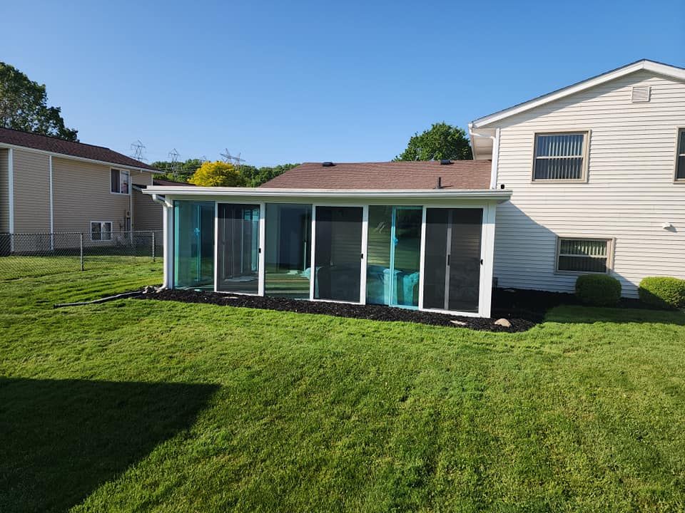 A house with a screened in porch in the backyard.