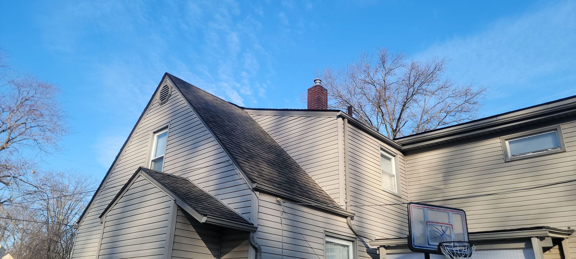 A house with a basketball hoop on the side of it.