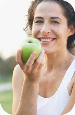 A Woman Holding A Green Apple — Clinton, TN — Premier Weight Management & Aestheics, LLC