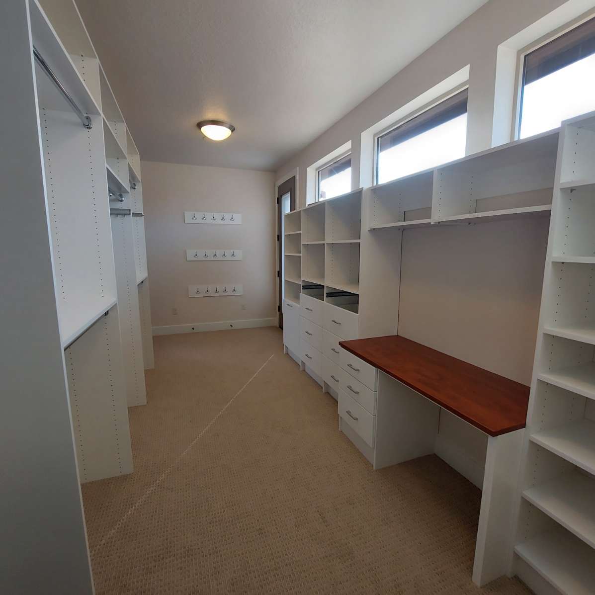 A walk in closet with lots of shelves and a desk