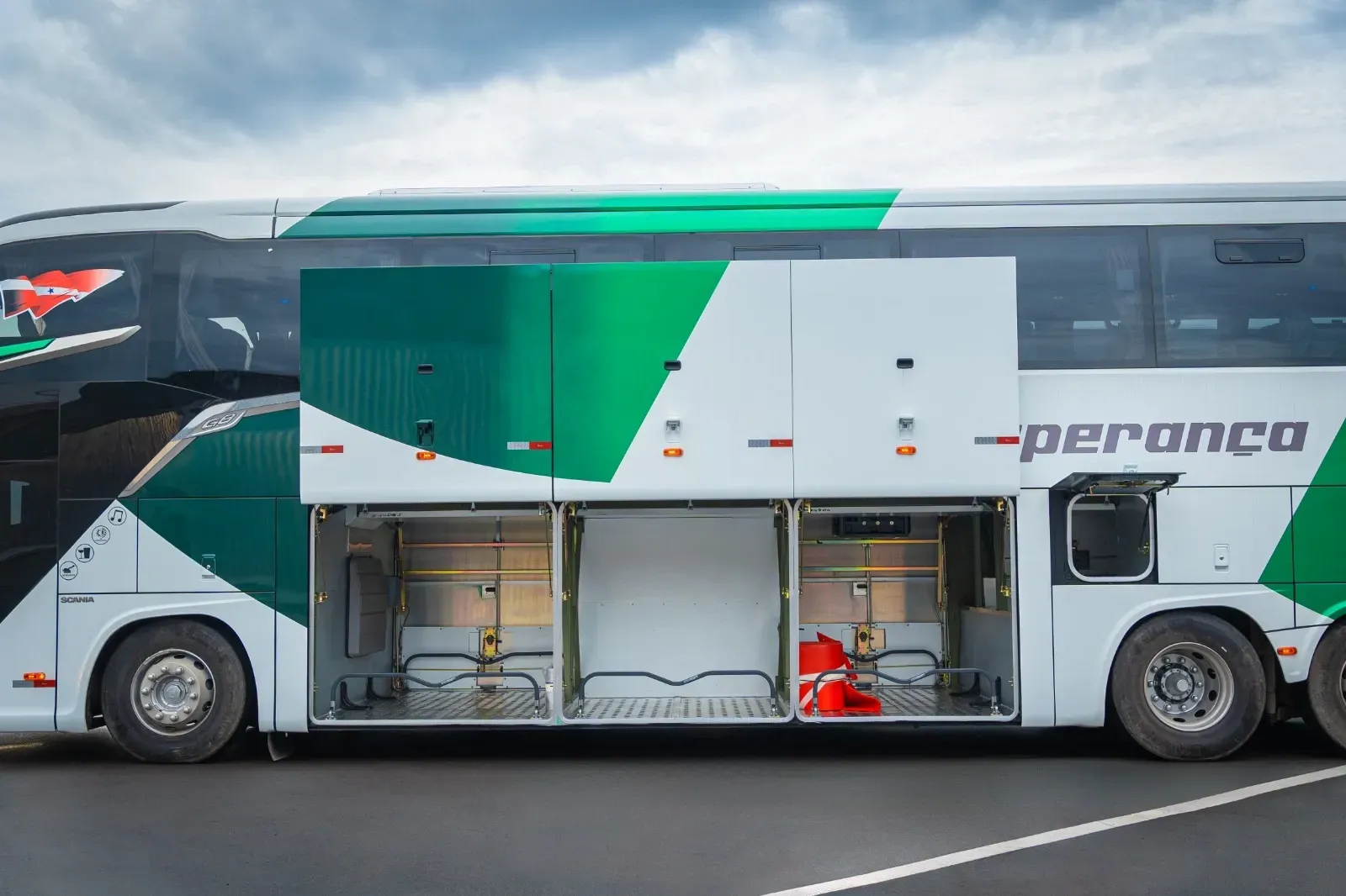 Um ônibus verde e branco com as portas abertas está estacionado em um estacionamento.