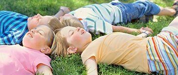 Children lying on the grass — Early Learning Center in Tiverton, RI