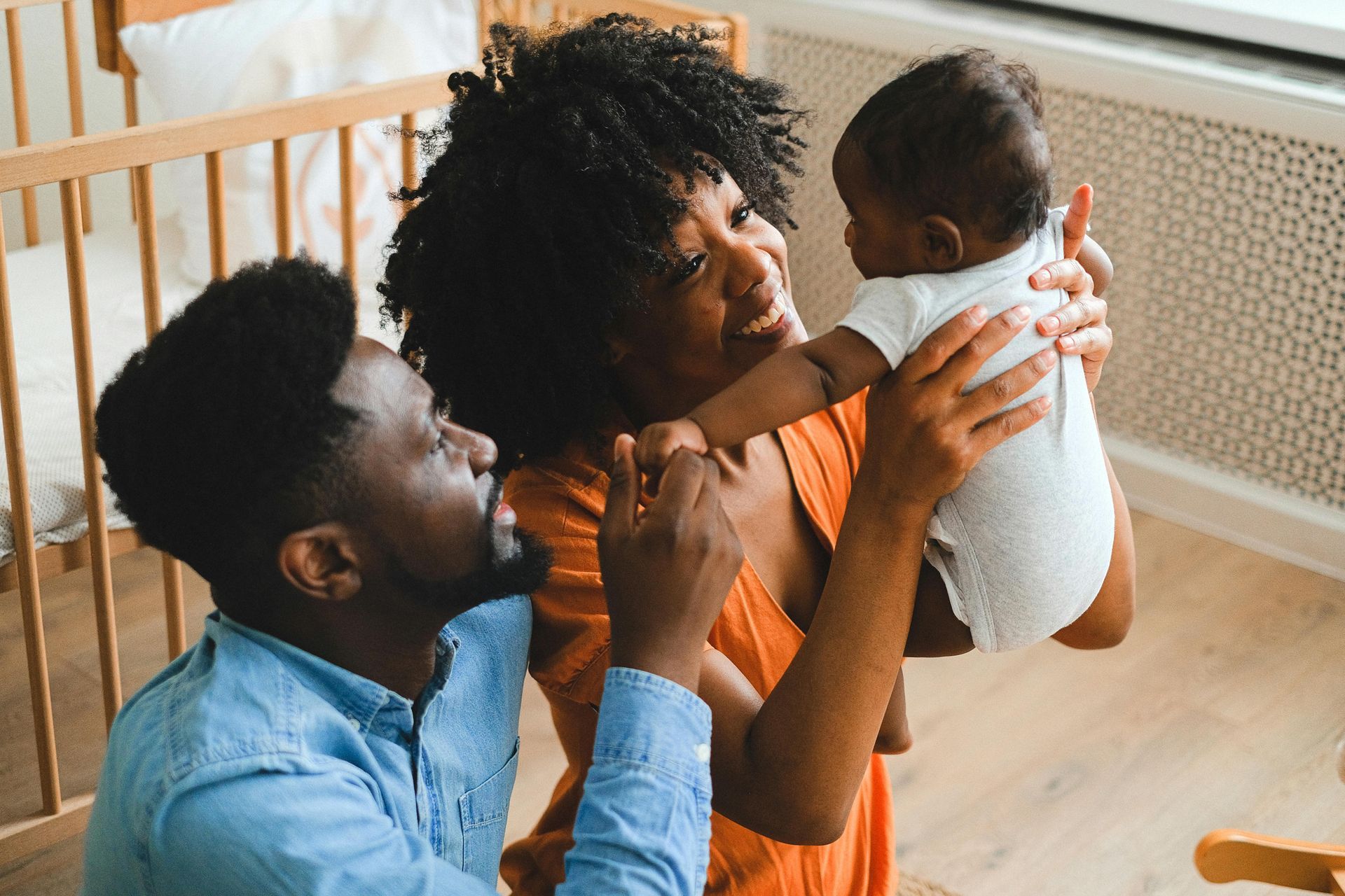 A man and a woman are holding a baby in their arms.