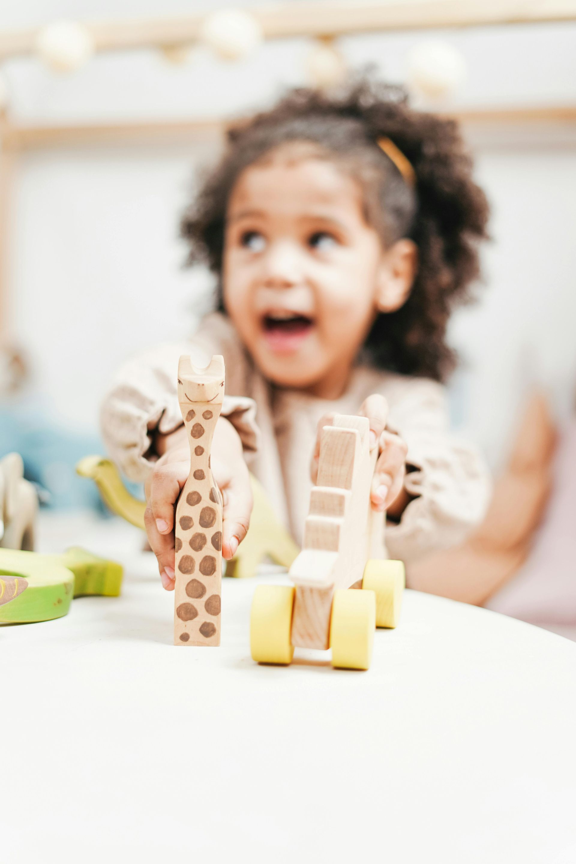 Family sits on a rug, playing with colorful blocks. Mother and father look at the child.