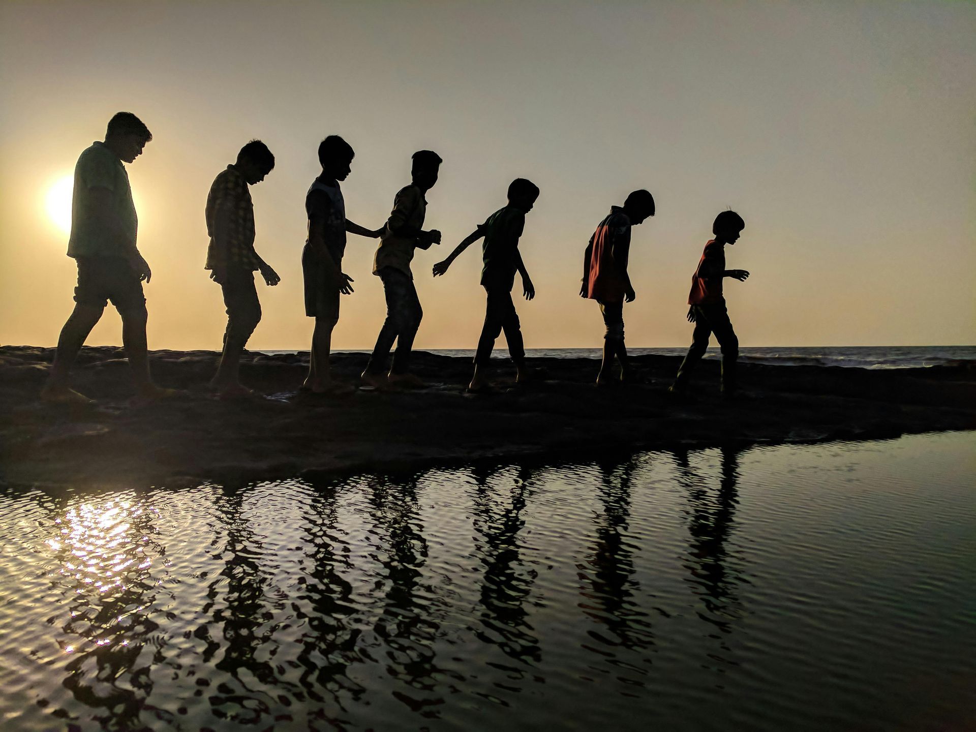 A group of people are walking across a body of water.