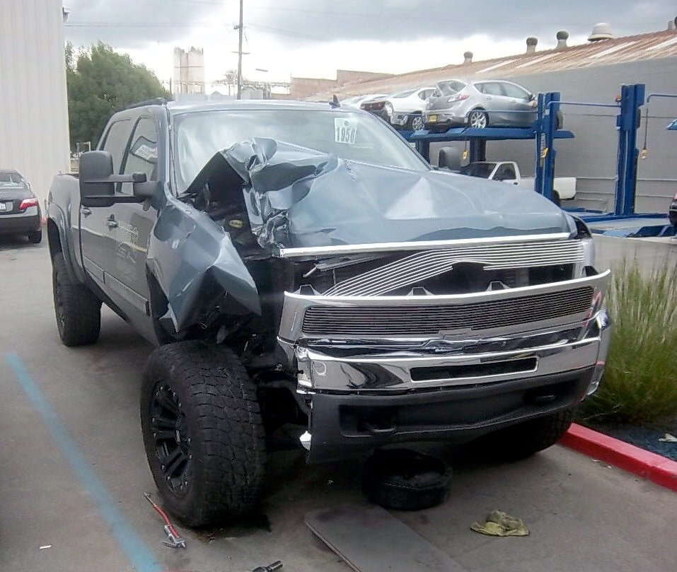 a damaged truck is parked in a parking lot