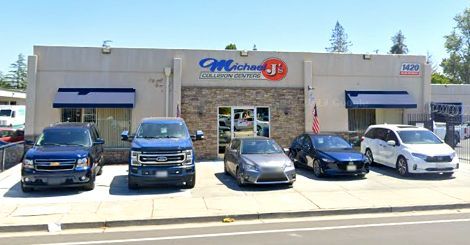 a row of cars are parked in front of a car shop .