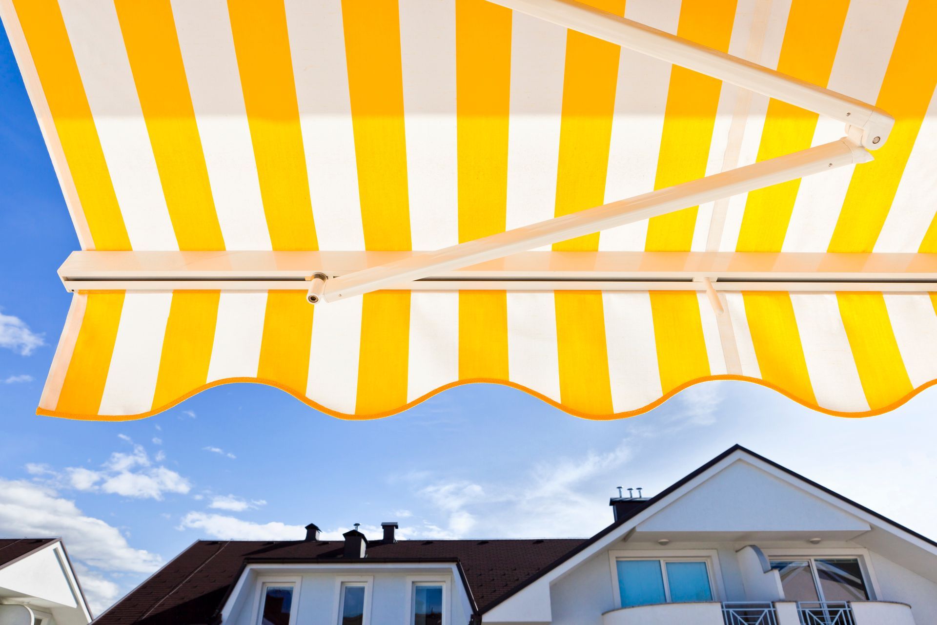 Close-up of a yellow-white striped awning, showcasing a local awnings service.