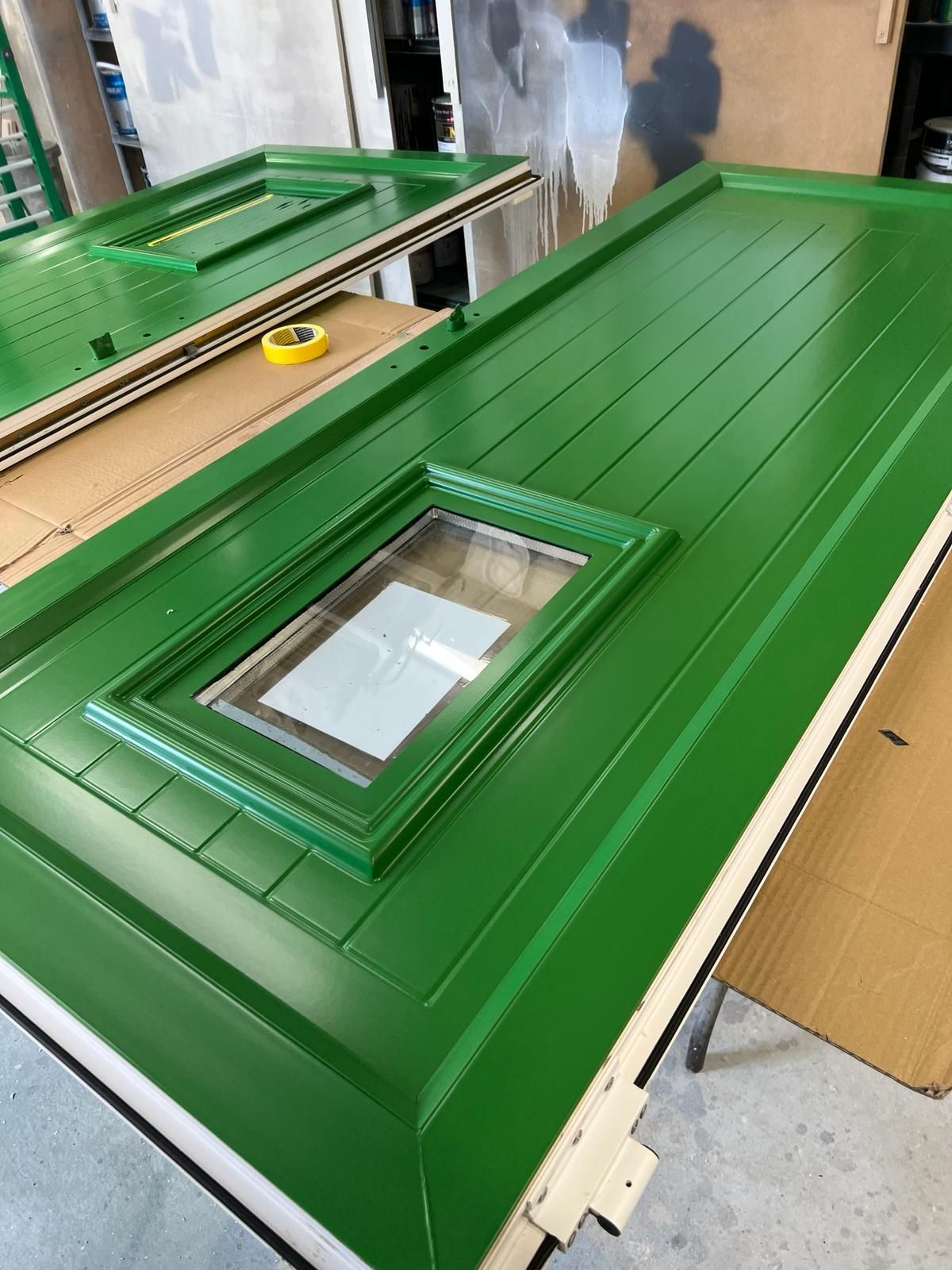 a green door with a window is sitting on a table .