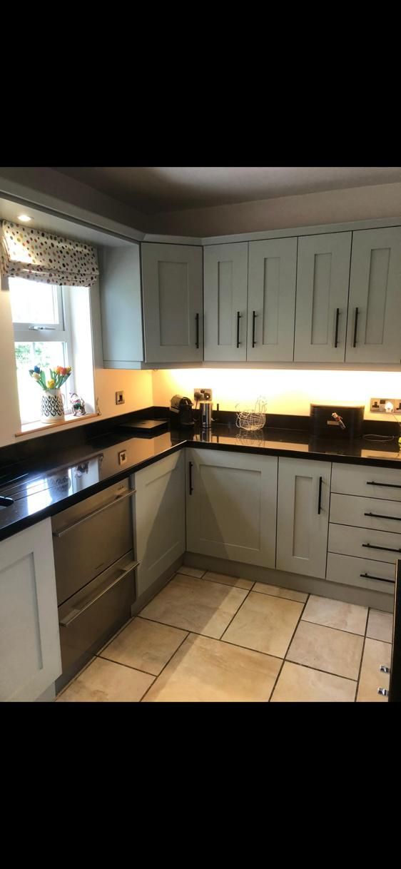 a kitchen with white cabinets and black counter tops .