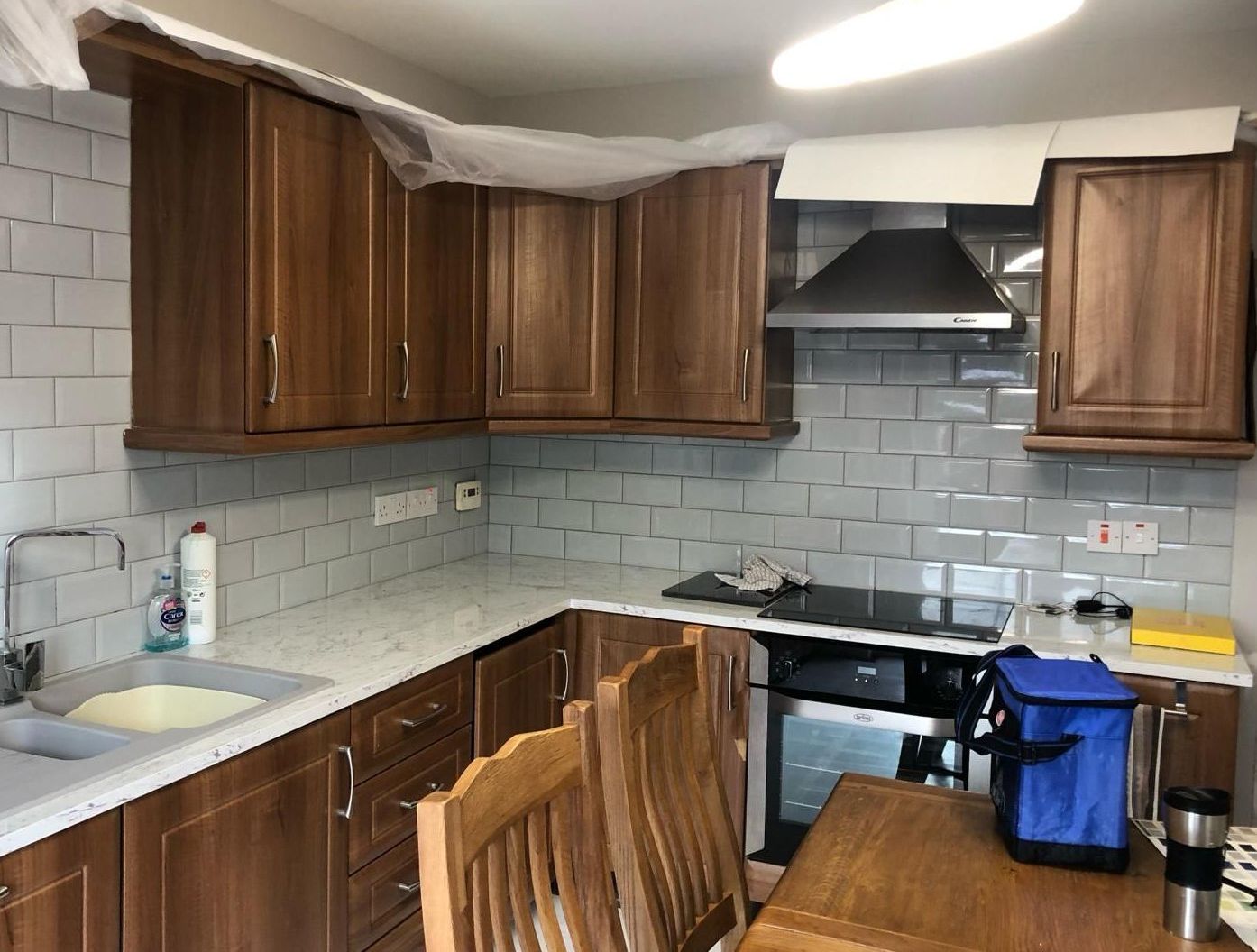 a kitchen with wooden cabinets and a blue bag on the counter .