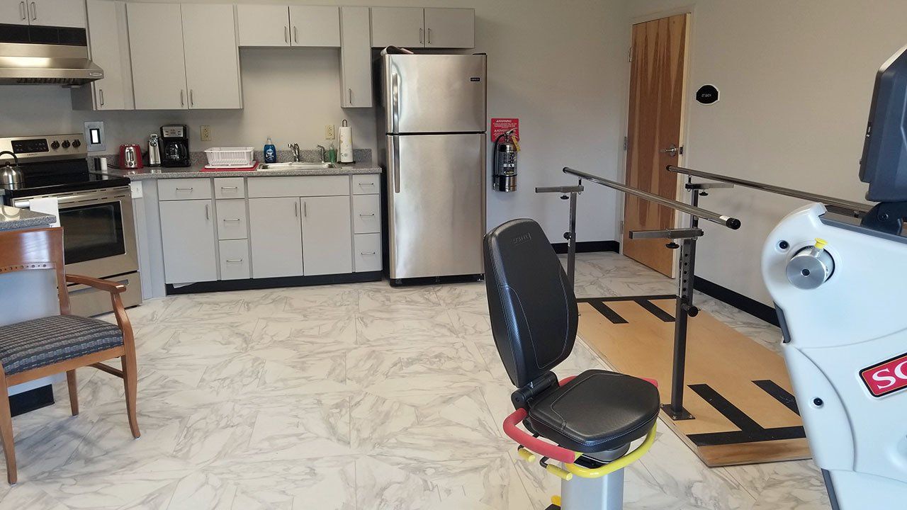 A kitchen with white cabinets and a stainless steel refrigerator