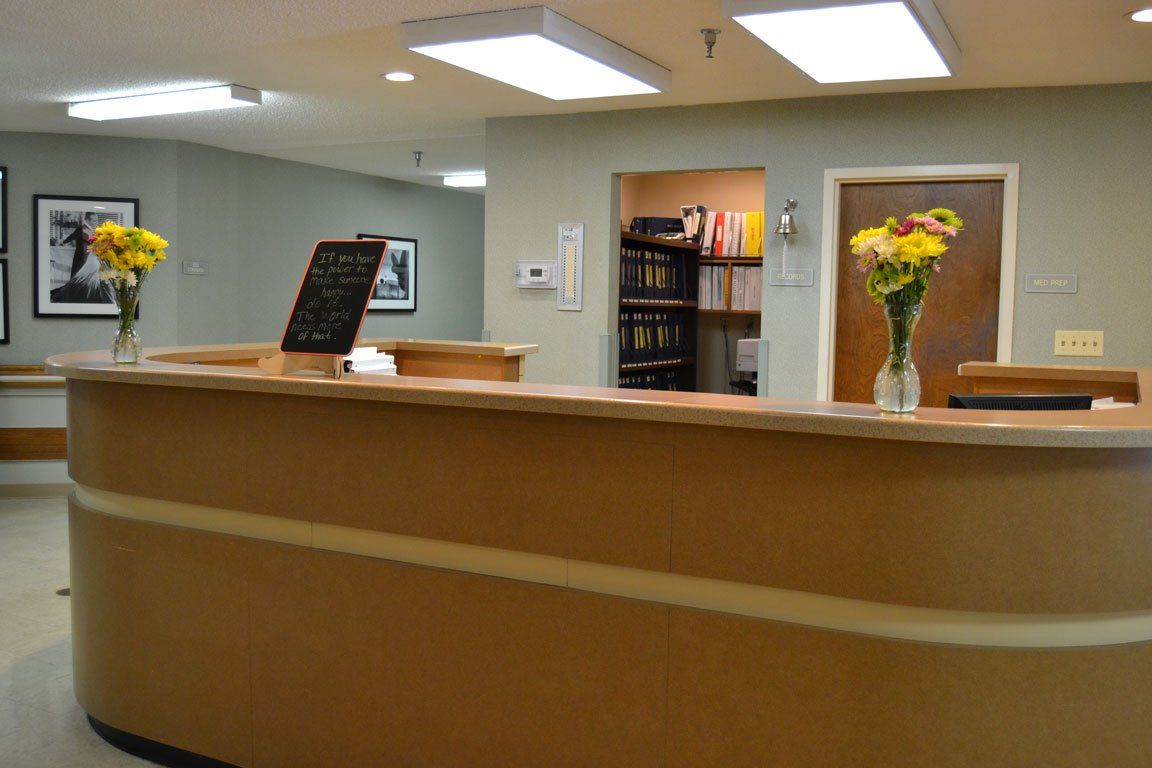 A reception desk with two vases of flowers on it