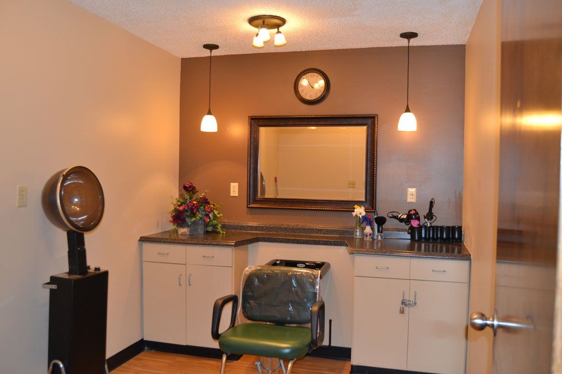 A hair salon with a green chair and a mirror
