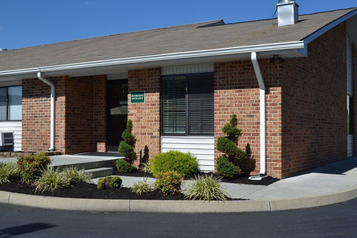 A brick house with a roof that has a chimney on it