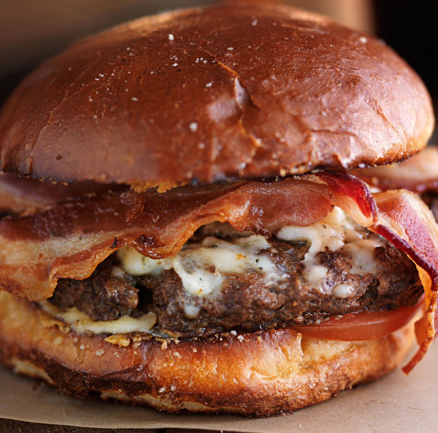 A close up of a hamburger with bacon and cheese