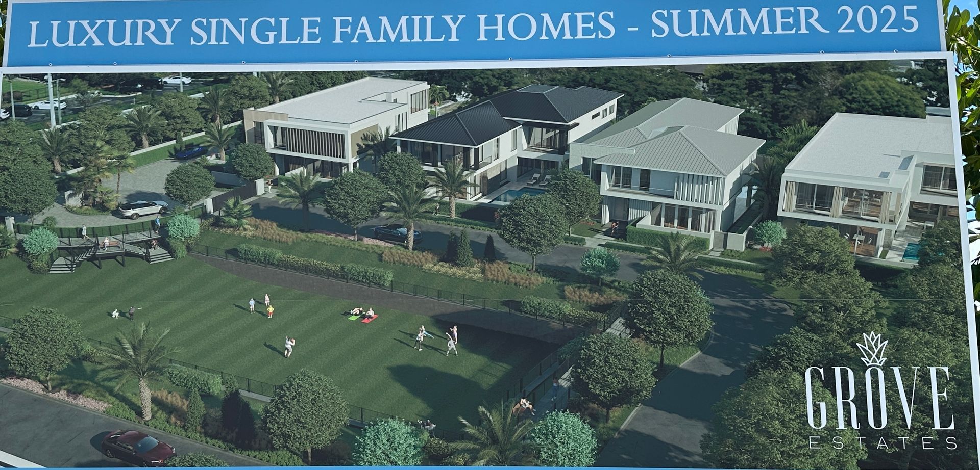 An aerial view of luxury single-family homes planned for Summer 2025, with a grassy park in the foreground.