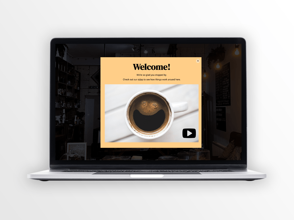 Laptop with a welcome message featuring a coffee cup with a smiley face on the screen.