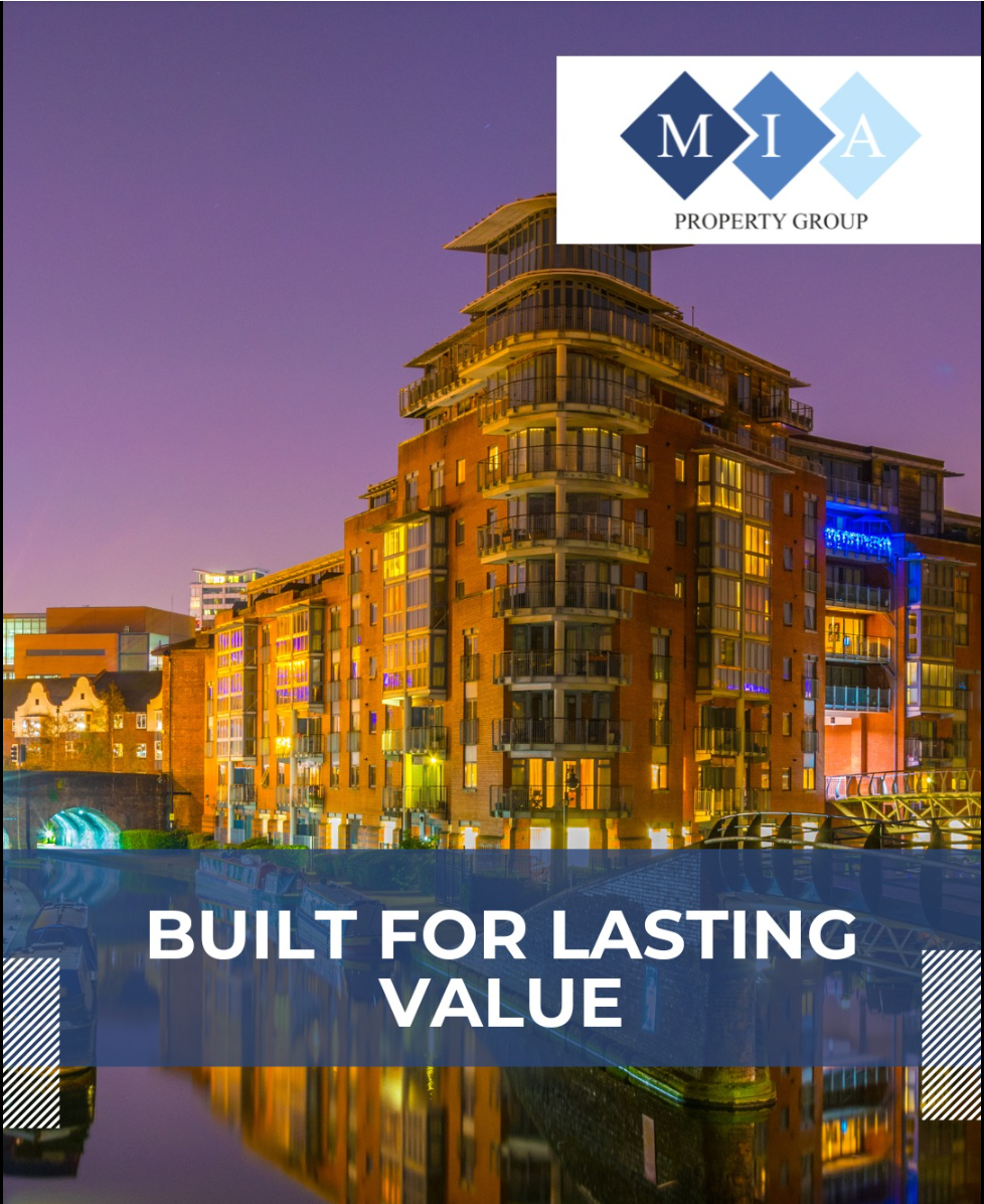 Building at night lit up, reflected in water.