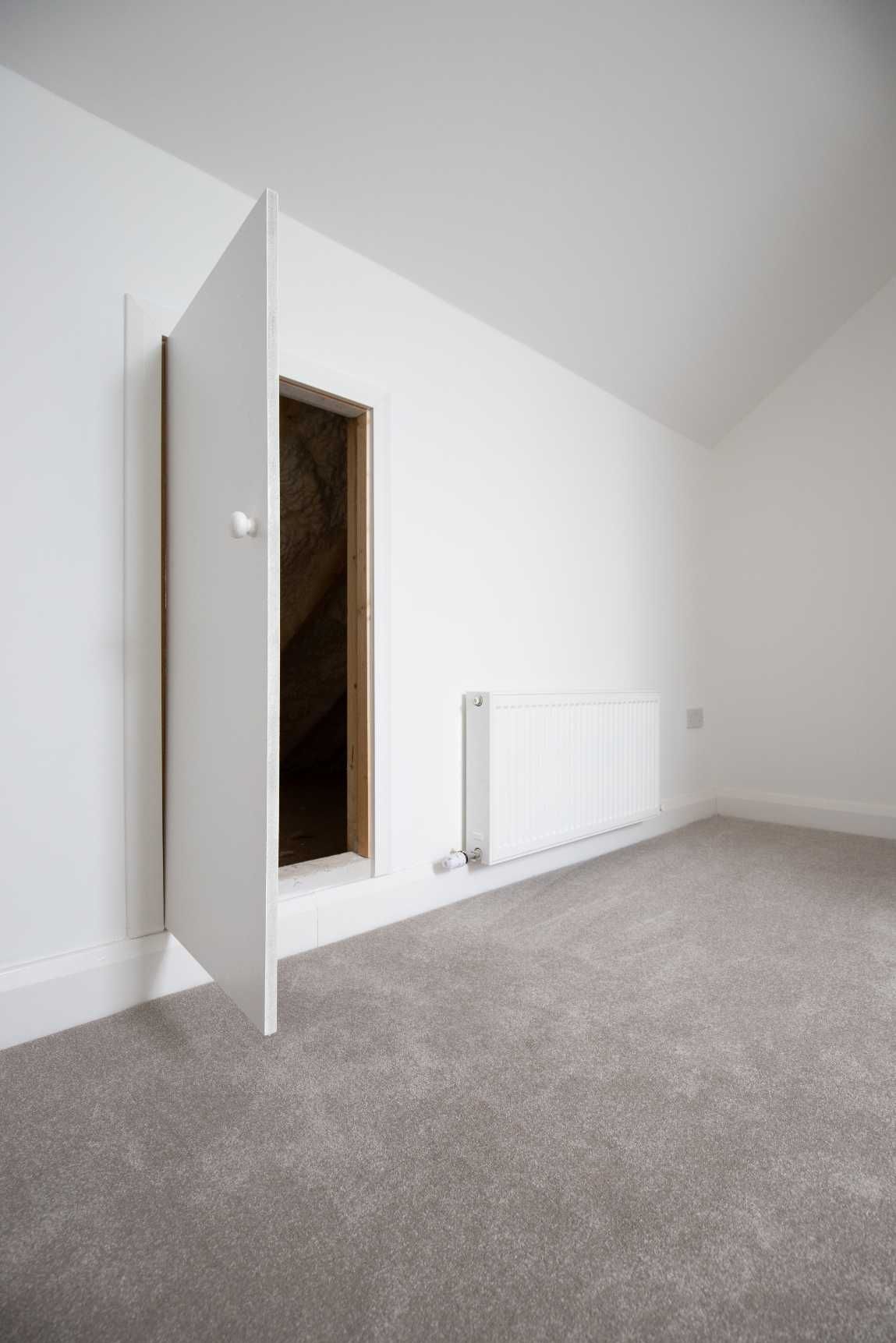 An empty room with a door open and a radiator.
