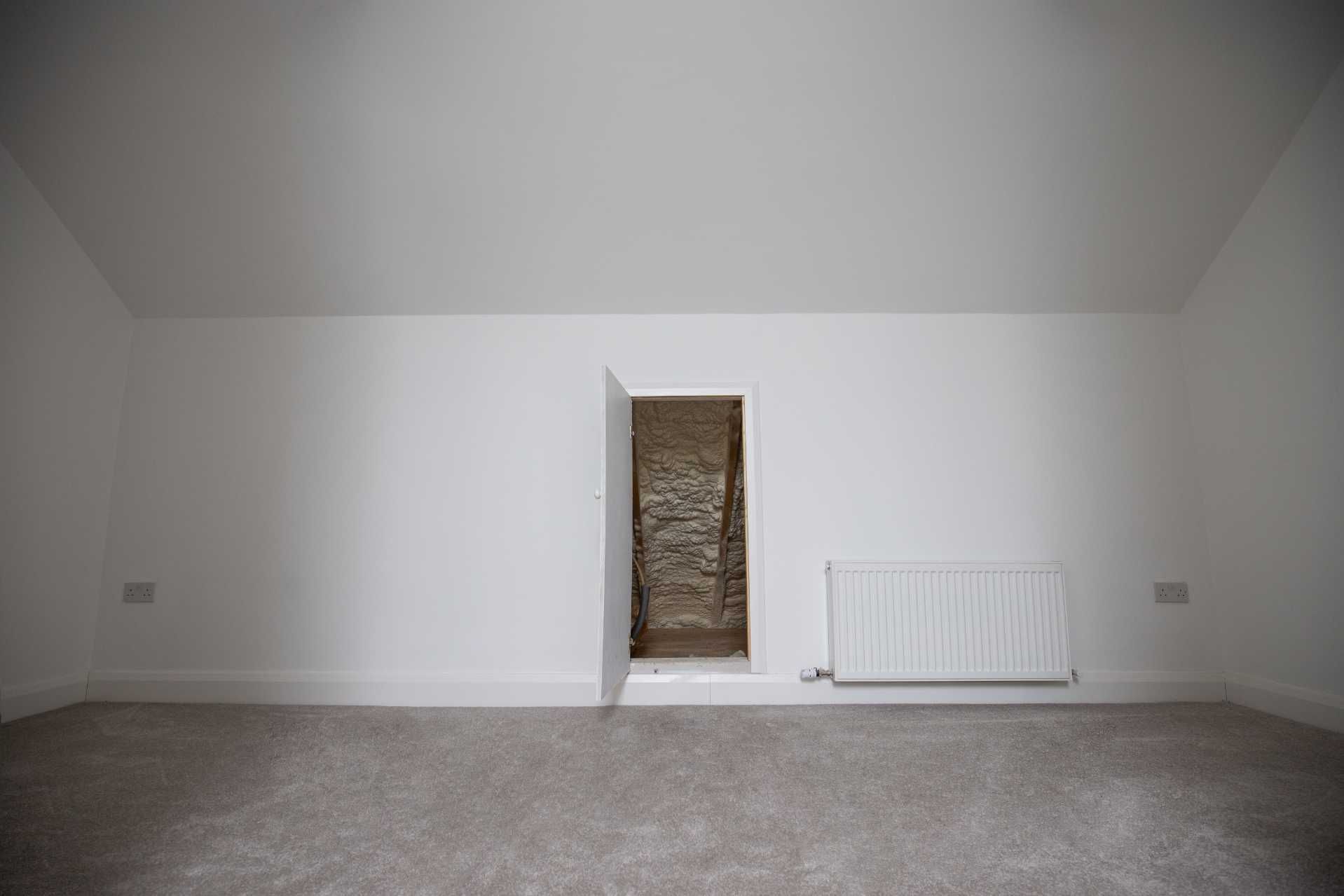 An empty room with a door open and a radiator.