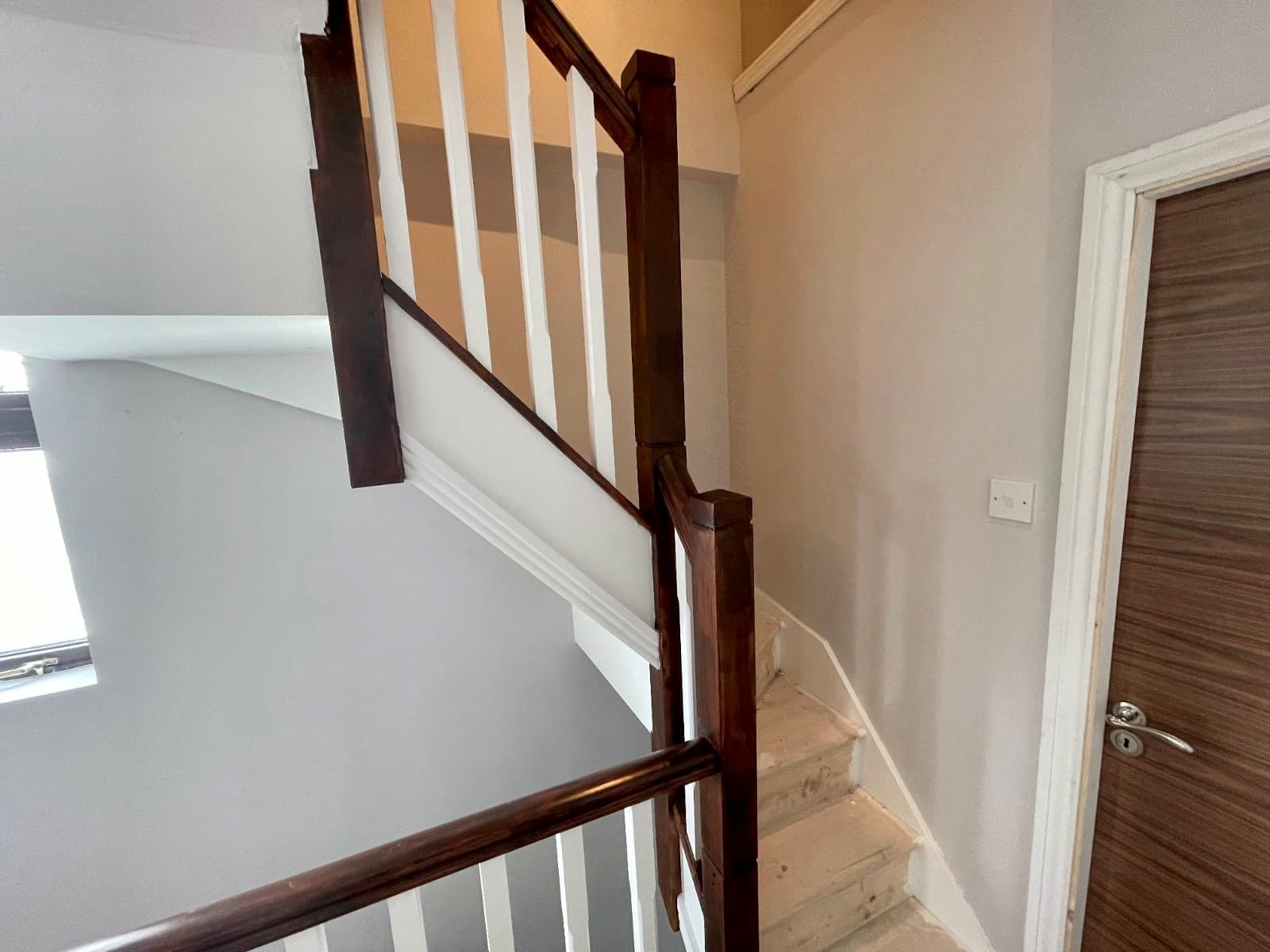 A staircase with a wooden railing and steps in a house.