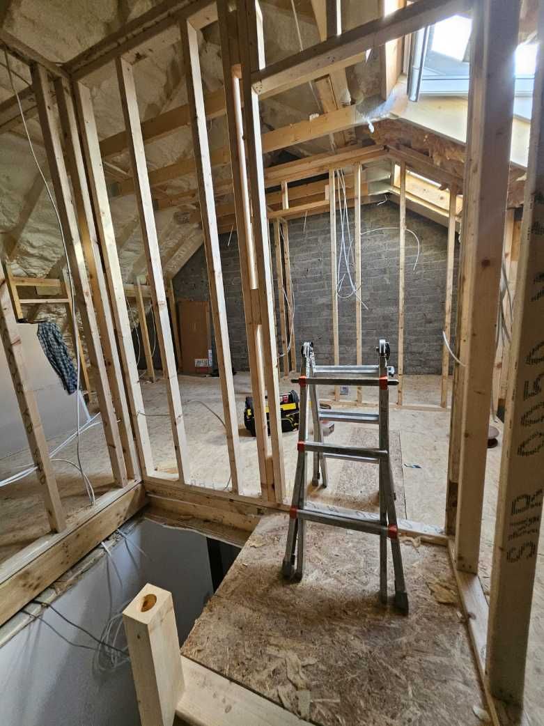 A ladder is sitting in the middle of a room under construction.