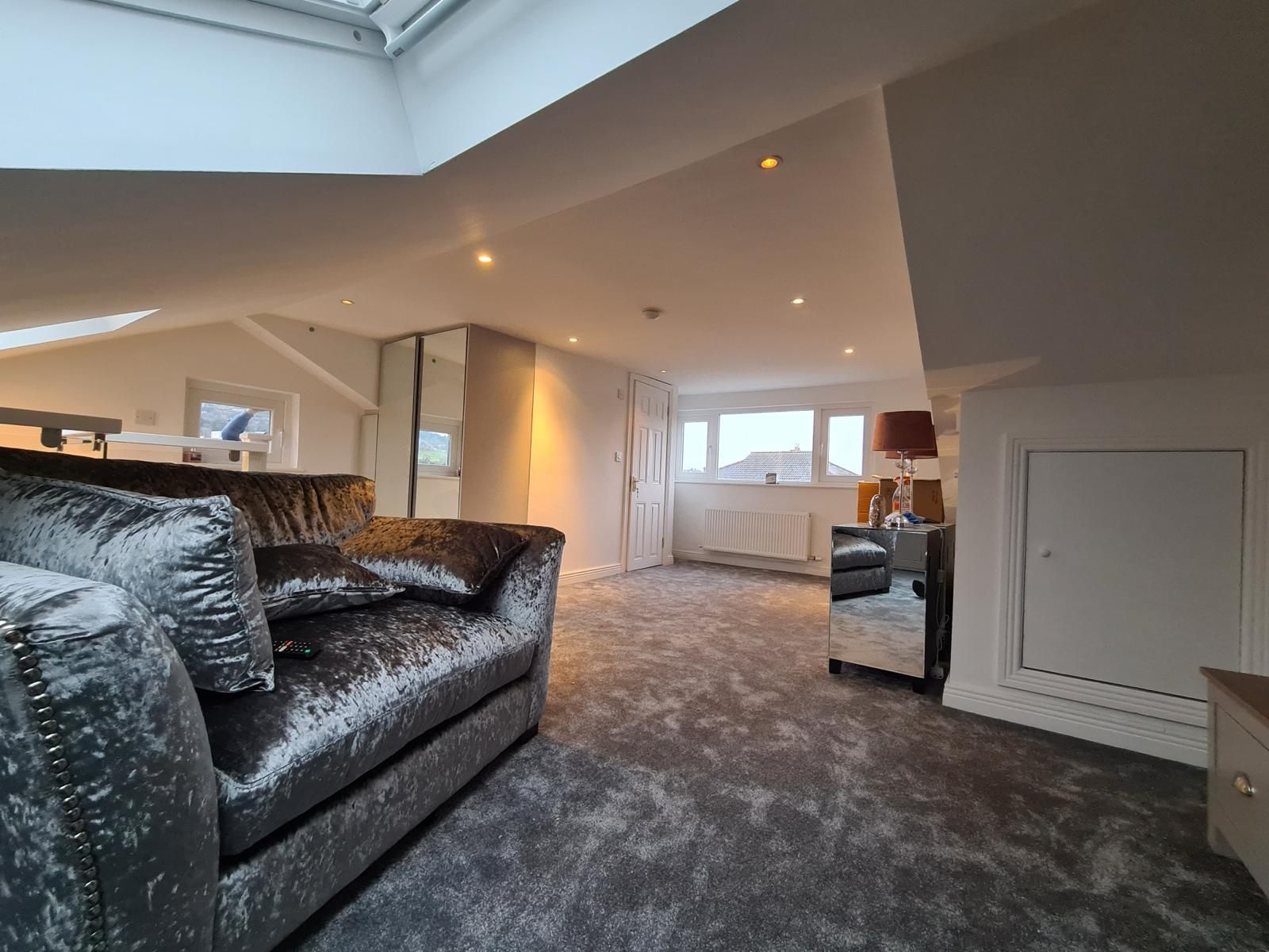 A living room with a couch , chair , and lamp.