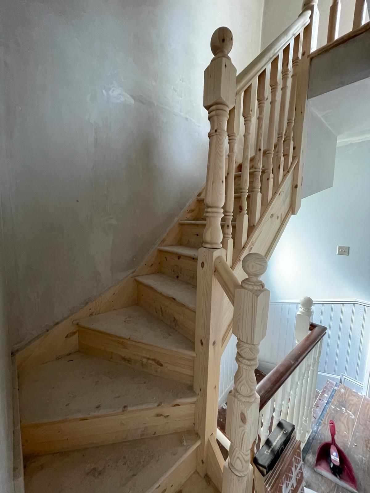 A wooden staircase with a white railing in a house.