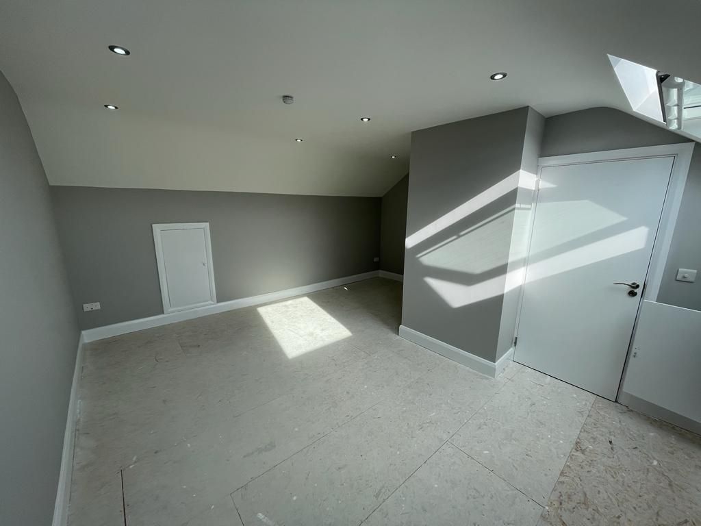 An empty room with gray walls and a white door.