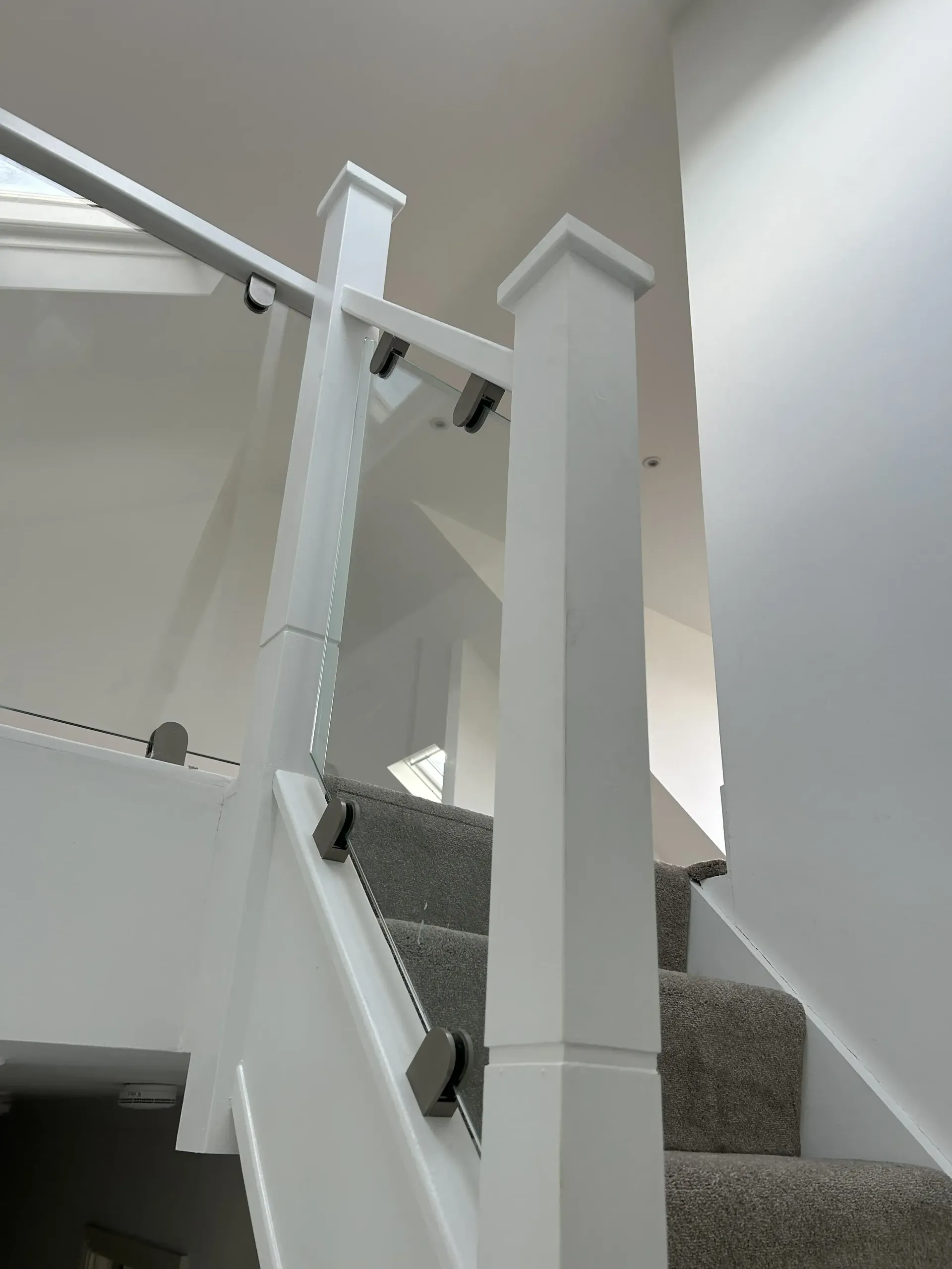 A staircase with a white railing and carpeted steps in a house.