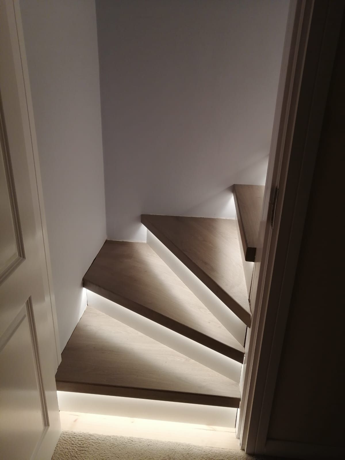 A wooden staircase with a light on the steps