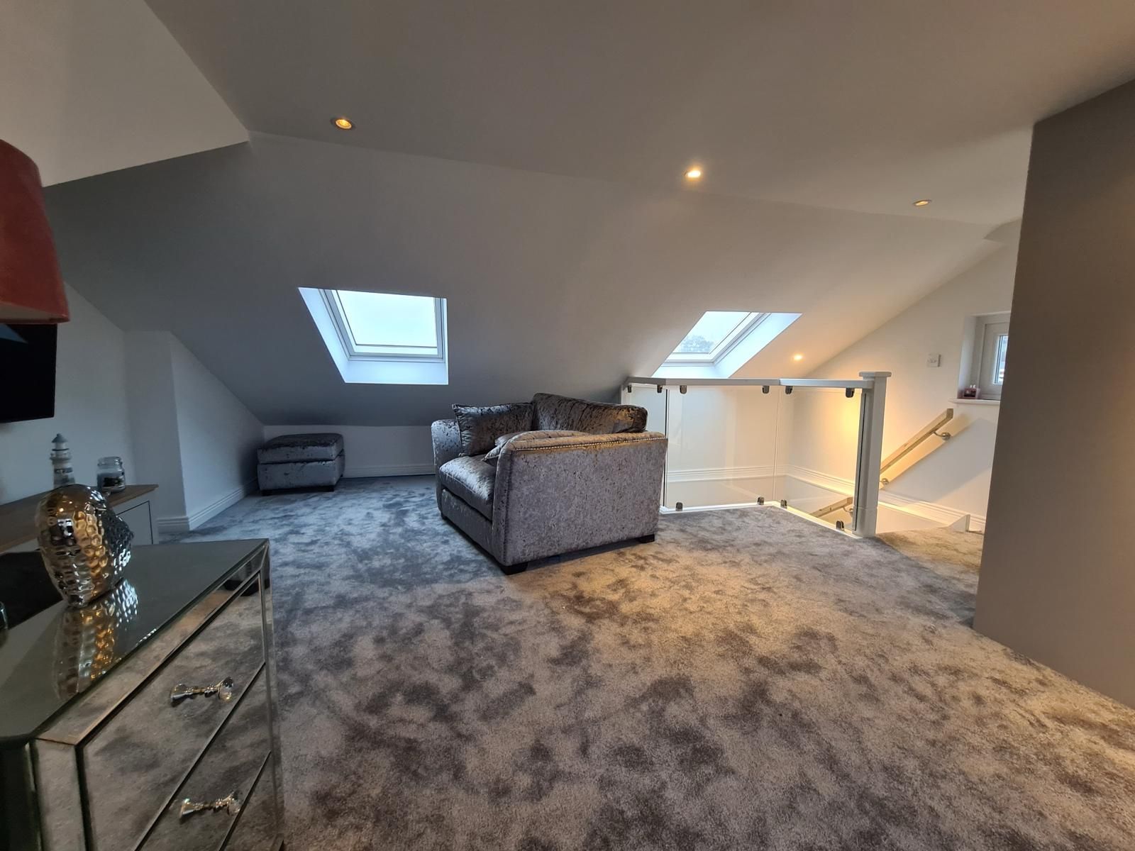 A living room with a couch , chair and dresser.