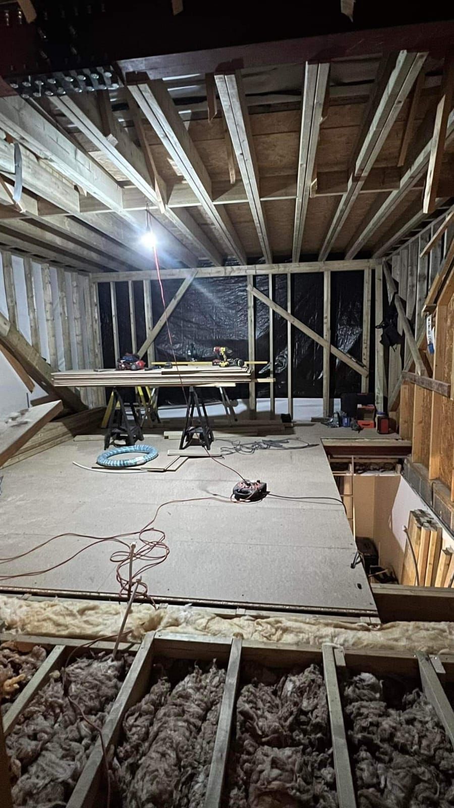 A room under construction with a wooden floor and a ceiling.